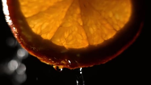 Wasser spritzt in Zeitlupe auf frische Orange