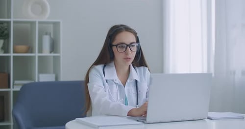 Hardworking Indian Female Doctor Doing Video Call on Laptop in Hospital. Smiling Young Female Doctor