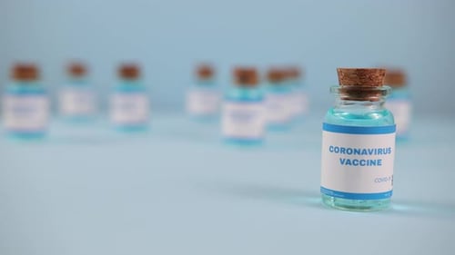 Coronavirus Vaccine Bottle Close Up on Blue