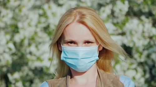 A Man in a Gauze Bandage Against a Background of Flowering Trees. Allergy During the Spring