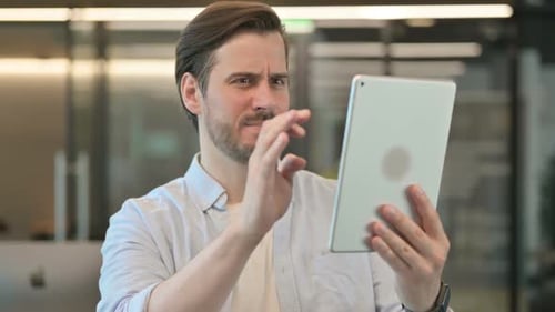 Man With Tablet Looking Confused and Upset