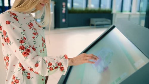 Mujer joven en busca de la dirección correcta en el tablero de navegación en Modern Mall