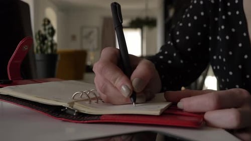 Closeup view as woman writing some notes in a notebook