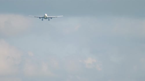 Commercial Airplane Approaching for Landing in Cloudy Sky