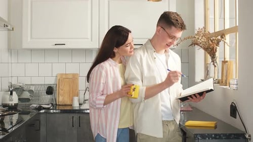Couple Writing Together in Bright Kitchen