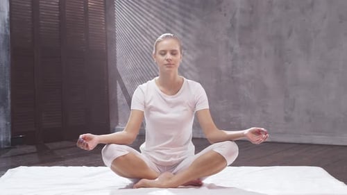 Woman Meditating in Lotus Pose in Studio
