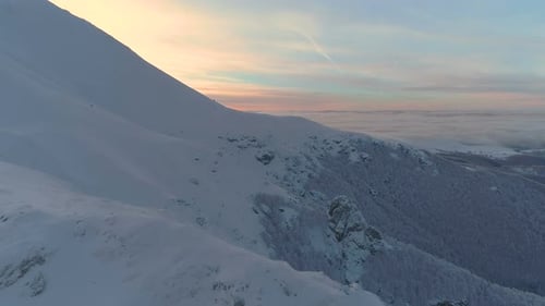 Aerial View of Snowy Mountain Landscape at Sunrise