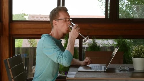 Man Working at Computer, Drinking Wine