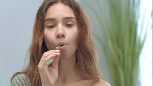 Woman Brushing Teeth in Bathroom Close Up