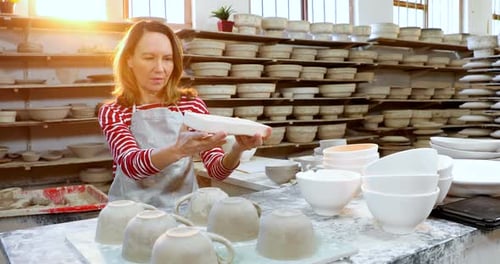Female potter checking craft product 4k