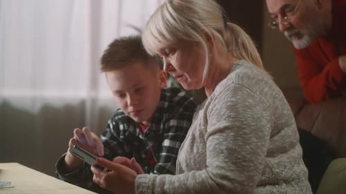 Grandmother and Grandson Play on Smartphone Together
