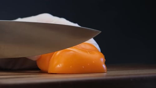 Vibrant Orange Bell Pepper Slice on Wooden Board