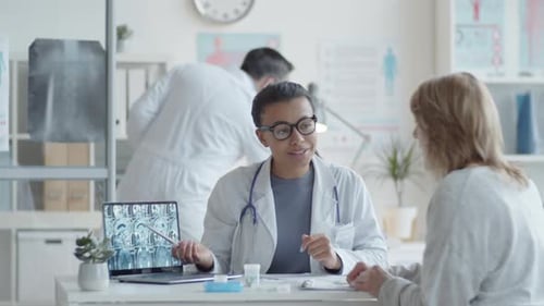 Doctor Explains Scan Results to Patient in Clinic
