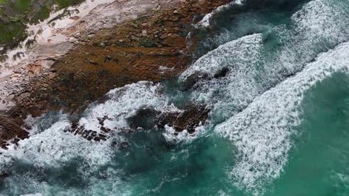 Beautiful Aerial Drone Shot of Waves Breaking onto a Rocky Beach in Cape Town South Africa,