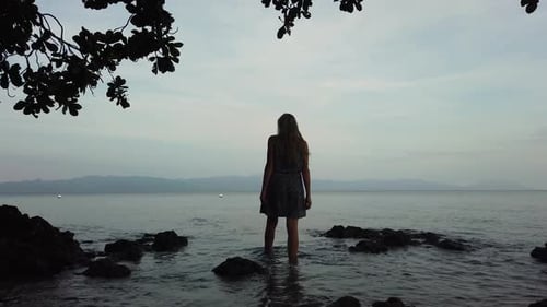 A Woman Enjoys a Sunset on the Beach