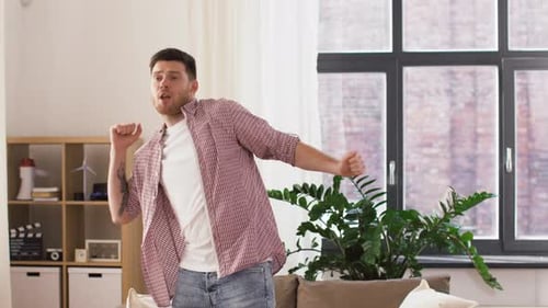 Happy Smiling Young Man Dancing at Home