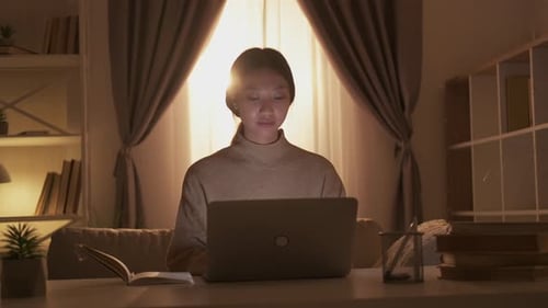 Young Adult Working on Laptop at Home Desk