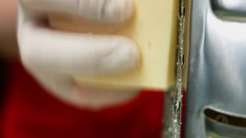 Cámara lenta de queso parmesano rallador, típico queso italiano, en el plato recién preparado