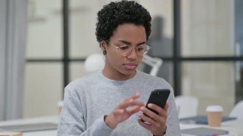 Young Adult Using Smartphone in Modern Office