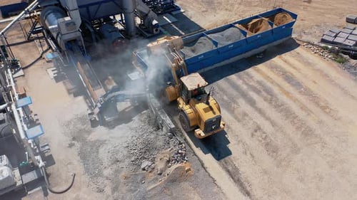 Front-End Loader Scooping at Industrial Workplace