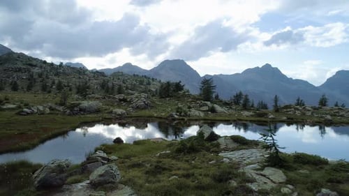 Moving Forward Above Clear Blue Lake and Tent Camp in Evening Summer Day