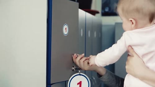 Woman Opens Locker While Holding Baby