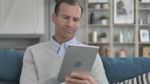 Man Using Tablet on Couch Indoors