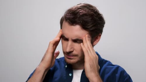 Man Holding Hands on Head. Closeup Tired Guy Having Headache in Studio