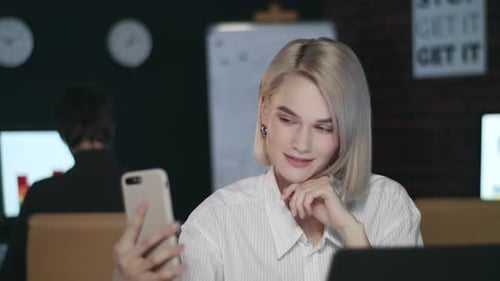 Attractive Business Woman Making Selfie on Mobile Phone in Dark Office