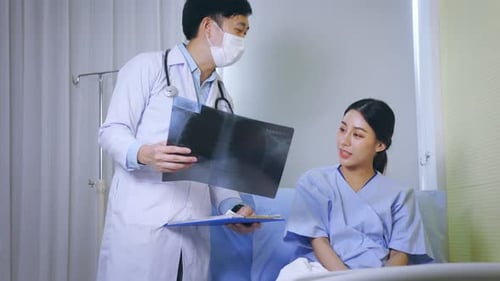 Doctor Explains X-Ray to Young Adult Patient in Hospital