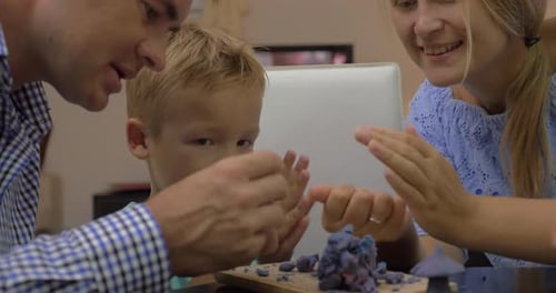 Family crafting playdough sculpture together in home