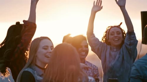 Young Adults Dancing at Outdoor Party at Sunset