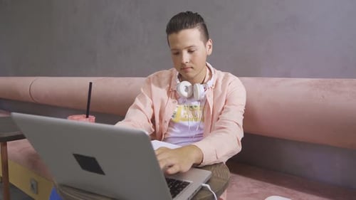 Man Studying with Laptop and Notebook in Urban Setting