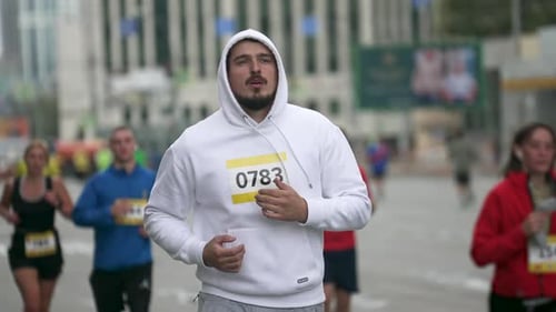 Deportista masculino con cuerpo gordo en un evento de maratón entre los atletas