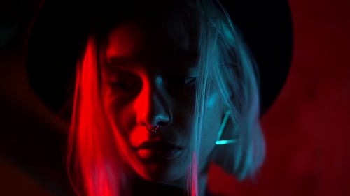 Young Woman Posing in Dramatic Red and Blue Lights