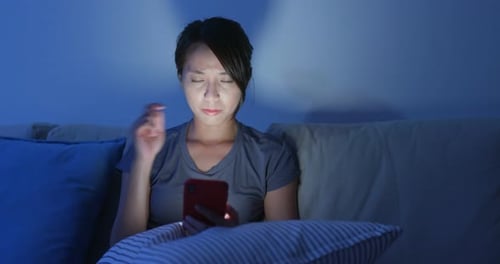 Woman Uses Phone in Bed at Night