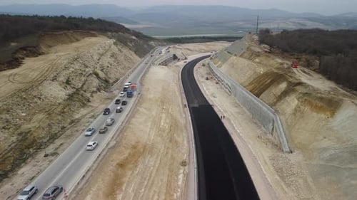 Gelber LKW gießt Bitumen über eine neue Straße