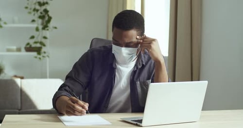Adult Working From Home with Mask and Laptop