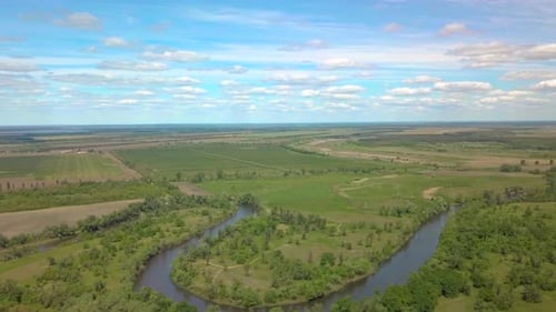 Flug über grüne Wiese, Wald und Fluss im Frühling