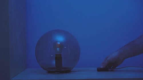 Nicht erkennbare Ernteperson, die die Lampe ein- und ausschaltet