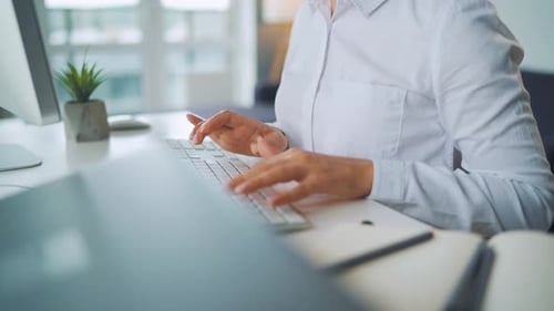 Woman Typing on Keyboard in Office Setting