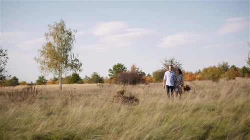 Young Couple Walking on a Meadow