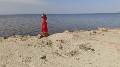 Beautiful Woman in Red Dress Posing on Beach