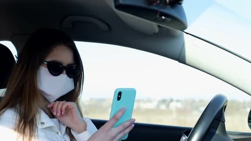 Woman Wearing Mask Using Cellphone in Car