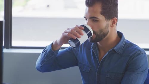 Businessman drinking coffee in modern office