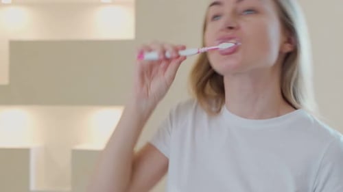 Young Woman Brushing Teeth in Bright Bathroom
