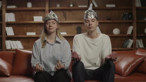 Young Couple Wearing Tin Foil Hats Meditating