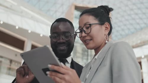 Colegas de trabalho com tablet discutindo o trabalho em ambientes fechados