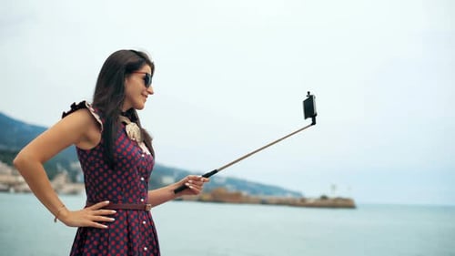 Woman Taking Selfie with Selfie Stick by the Sea