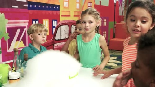 Children watch science experiment producing vapor
